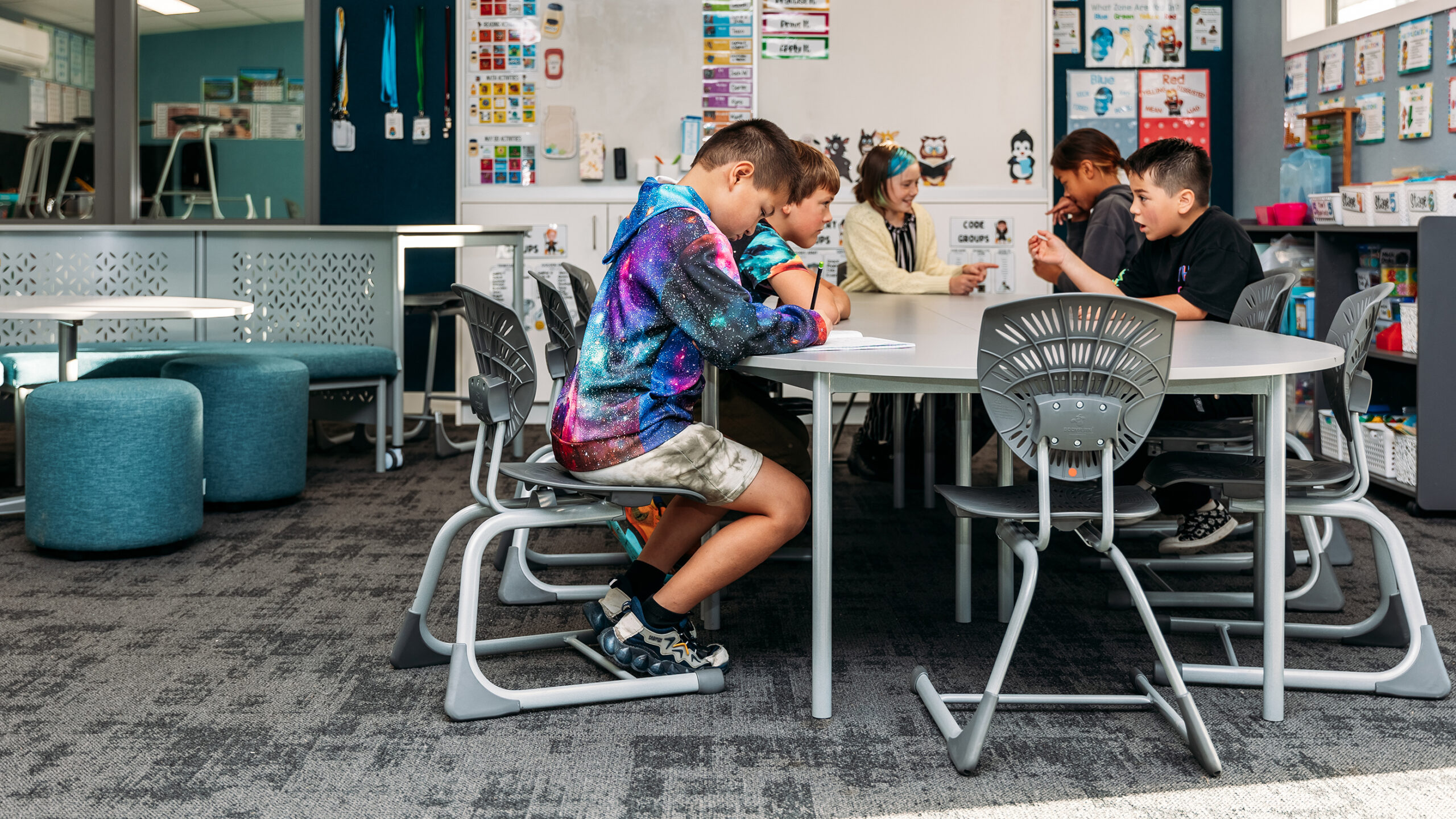 Students using Bodyfurn.Flex chairs in a modern collaborative classroom environment.