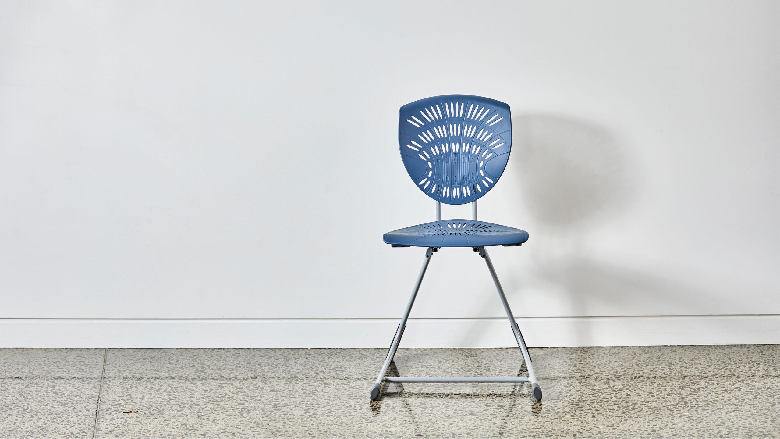 Blue Bodyfurn.Flex sled chair against a white wall in a learning space