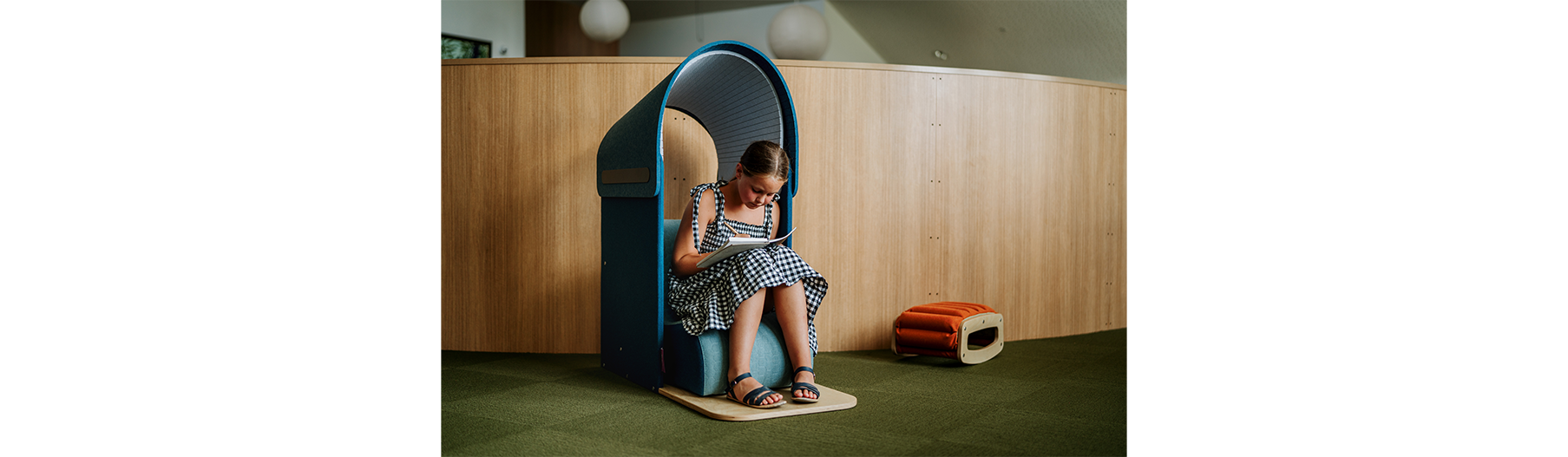 Student using the Furnware Hideaway Hood and Rocker for focused, sensory-friendly learning within an inclusive classroom environment.