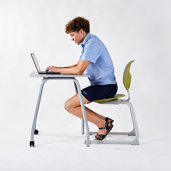 Student seated on a Bodyfurn.Flex chair using a laptop at a Switch Mini desk.