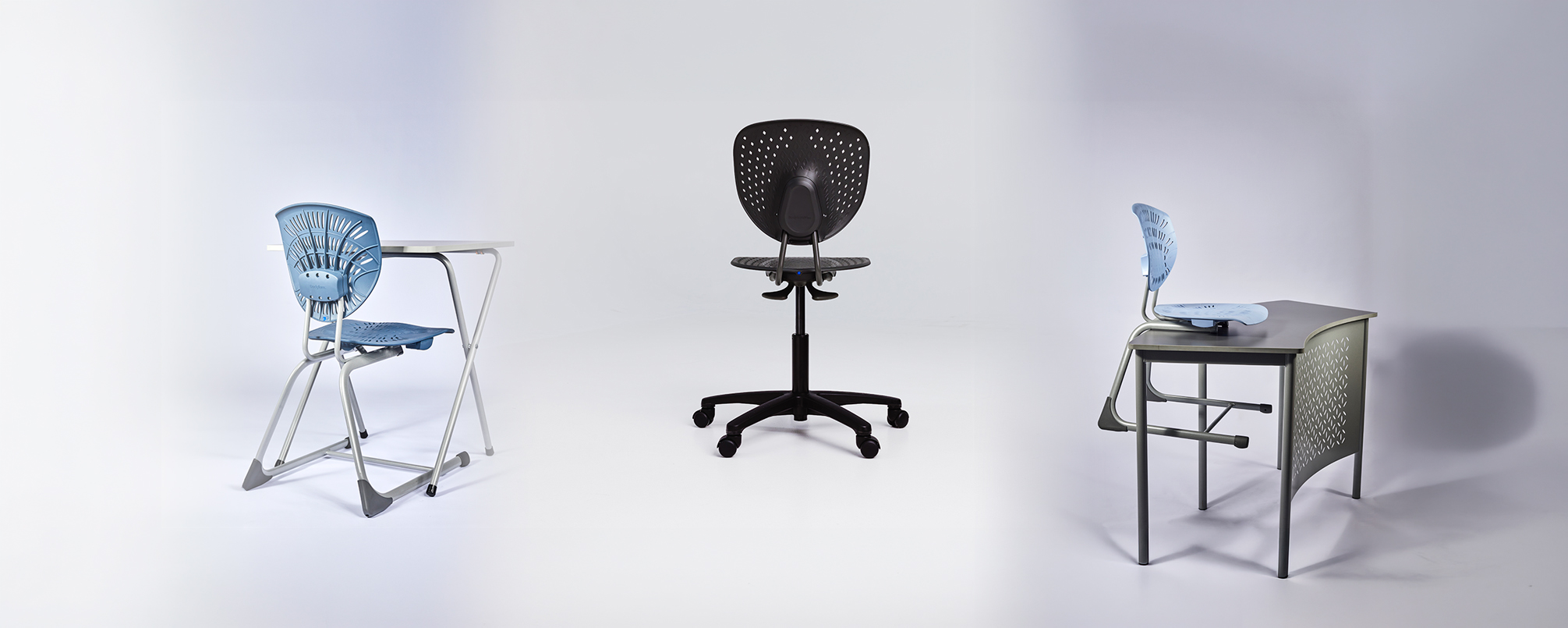 Deep Blue Bodyfurn sled chair with an Exam Desk, Black Bodyfurn gas-lift chair, and Light Blue Bodyfurn sled chair with a Base Curve Table