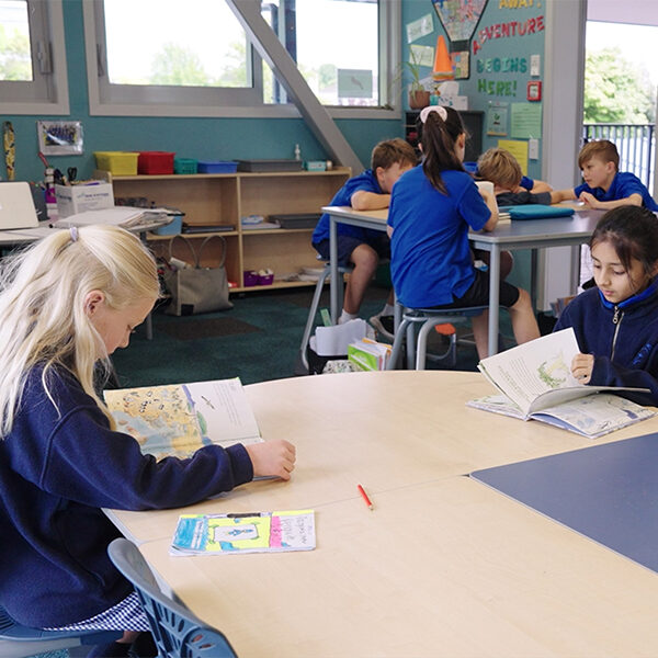 Students reading and working together in an Elmwood Normal School students in classroom with ergonomic Bodyfurn chairs.