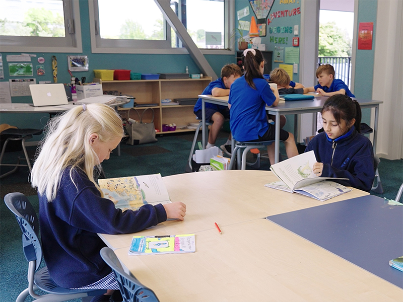 Students reading and working together in an Elmwood Normal School students in classroom with ergonomic Bodyfurn chairs.