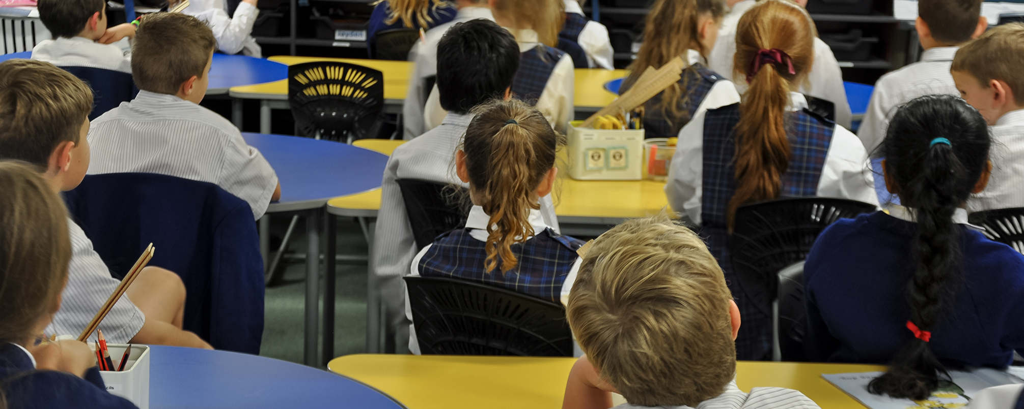 Students learning together in a classroom furnished with colourful tables and ergonomic seating