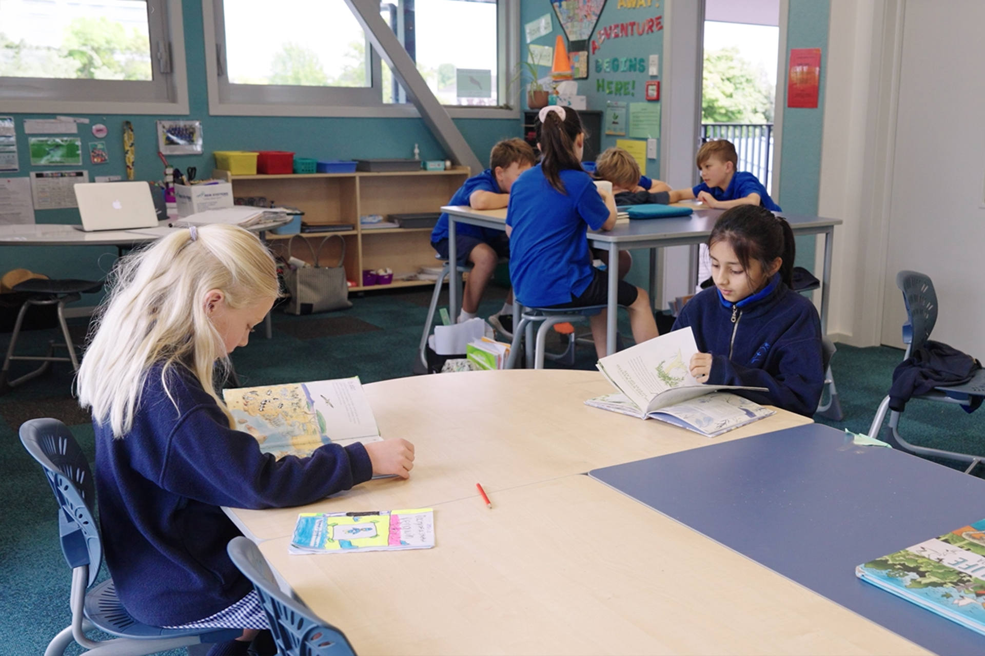 Students reading and working together in an Elmwood Normal School students in classroom with ergonomic Bodyfurn chairs.